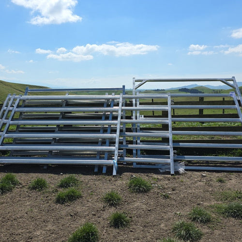 Straight run of assembled yard panels on a rural section, with rolling hills and blue sky in the background.